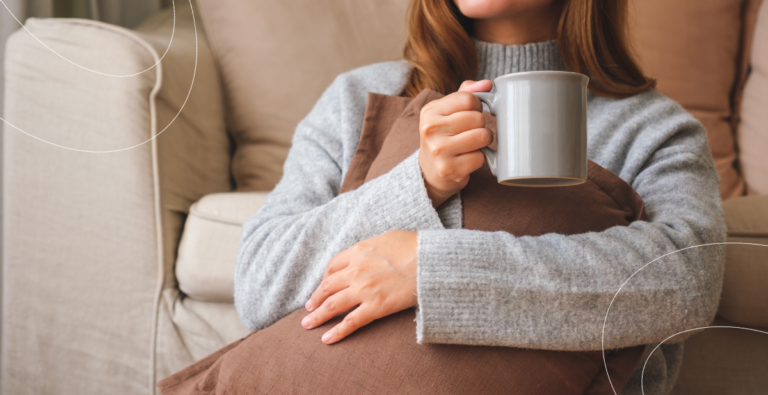 Mujer abrigada tomando un café durante el invierno, ilustrando la temporada de bajas temperaturas y la prevención de virus respiratorios.