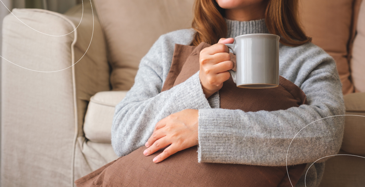 Mujer abrigada tomando un café durante el invierno, ilustrando la temporada de bajas temperaturas y la prevención de virus respiratorios.