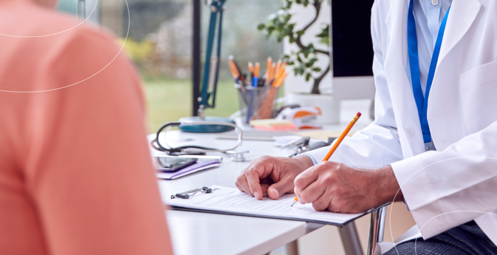 Médico escribiendo en un formulario durante una consulta preventiva para el control del VPH.